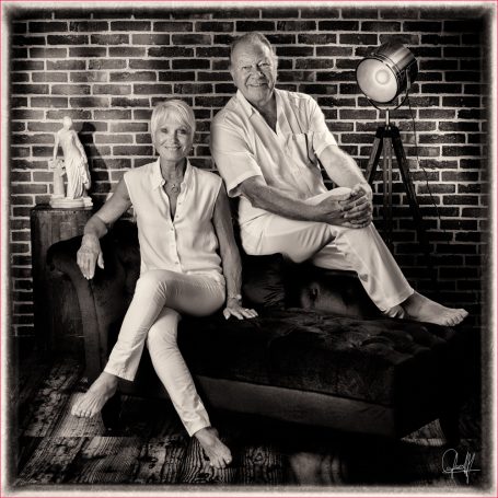 Portrait de couple quinquagénaire en noir et blanc dans un loft, moment tendre et élégant au Studio Boudoir